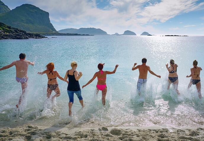 groupe de personnes courant dans l'eau à la plage